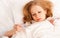 Woman with thermometer sick colds, flu, fever in bed