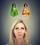 Woman thinking making a diet choice looking up at junk food and green vegetables shaped as light bulb