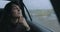 Woman thinking sitting in a car at rainy day looking at window