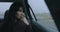 Woman thinking sitting in a car at rainy day looking at window