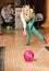 Woman throwing ball in a bowling club