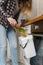 Woman throwing compostable food peels in a bokashi bin with compost and bran