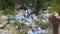 Woman throwing disposable cap into open dumping in the middle of forest, ecology