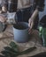 A woman is throwing a drainage into pot for preparing planting a young sprout