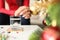 Woman throwing effervescent soluble pill into glass of water at home near christmas tree closeup