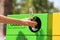 Woman throwing glass bottle into sorting bin on city street, closeup