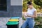 Woman throwing out in recycling bin washed and empty shampoo and deodorant bottles. Female looks at the packages to find