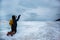 Woman throwing snow while kneeling on frozen wave