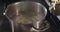 Woman throwing spaghetti pasta into boiling water. Overhead shot.