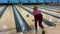 A woman throws a bowling ball along the path