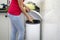 A woman throws garbage in the trash in the kitchen