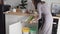 Woman throws glass and plastic bottles into containers of different colors for separate collection of food waste in modern kitchen