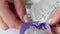 A woman ties a bow on a bouquet of lavender. Bouquet in craft paper. Close-up shot