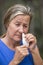 Woman tissue in nose suffering hayfever allergy