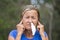 Woman with tissue in running nose and finger in ears