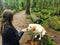 A woman about to feed her pet yellow lab a dog treat while walking in pacific spirit regional park. Vancouver, Canada.