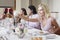 Woman Toasting Red Wine With Friends At Dinner Table