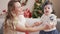 Woman and toddler standing on sofa by christmas tree at home