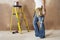 Woman With Toolbelt And Hammer Leaning Against Wall