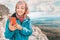 Woman on top of a mountain connects to a GPS Navigator and an app on her phone to chat with friends. Cellular Communication