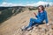 Woman on top of a mountain connects to a GPS Navigator and an app on her phone to chat with friends. Cellular Communication