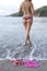 Woman topless tropical beach shoes bikini