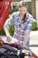 Woman Topping Up Windshield Washer Fluid In Car