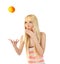 Woman tossing up an orange