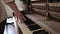 Woman touch keyboard of vintage wooden piano