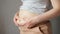 Woman touches fat on flabby sagging belly after pregnancy