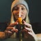 Woman touches with a fingers a candlestick with burned candle. Romantic, atmospheric on a dark, background