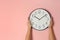 Woman touching clock on color wall, space