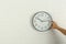 Woman touching clock on white brick wall, space for text