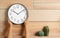 Woman touching clock on wooden wall, space