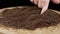 Woman Touching Dry Black Tea Granules with Finger on Rotating Wooden Background