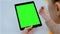 Woman touching green screen touchscreen display of black digital tablet at home