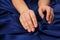 Woman touching silky blue fabric, closeup