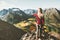 Woman tourist alone standing on cliff aerial mountains