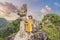 Woman tourist on background of amazing huge dragon statue at limestone mountain top near Hang Mua view point at foggy