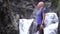 Woman tourist on the background of a waterfall. Young woman on a hike next to a waterfall and a mountain river