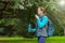 woman tourist with a backpack holds a thermos in her hands. forest, nature, hiking, active lifestyle, camping