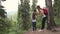 Woman tourist with a backpack walks through the forest with a child. The little girl is looking through binoculars