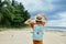 Woman tourist blue backpack walking on sandy beach island Exotic palm trees