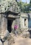 Woman the tourist with the camera at an entrance to ruins of the destroyed temple, Siem Reap, Cambodia