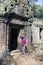 The woman the tourist with the camera at an entrance to ruins of the destroyed temple, Siem Reap, Cambodia