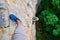 Woman tourist climbing a vertical, difficult via ferrata section in Baia de Fier, Romania, on a route called Dragons Amphitheater