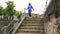 Woman Tourist Coming To Railing Of Embankment And Go Down The Stairs To River