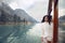 Woman tourist in cozy sweater enjoying on boat in Konigssee lake