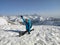 A woman tourist is doing splits on the top of the mountain.