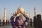 Woman tourist doing yoga mudra infront of Taj Mahal